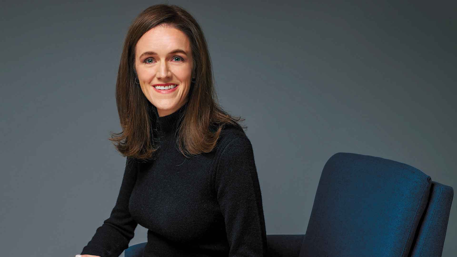 New CIO Kelly Doney seated in a blue armchair