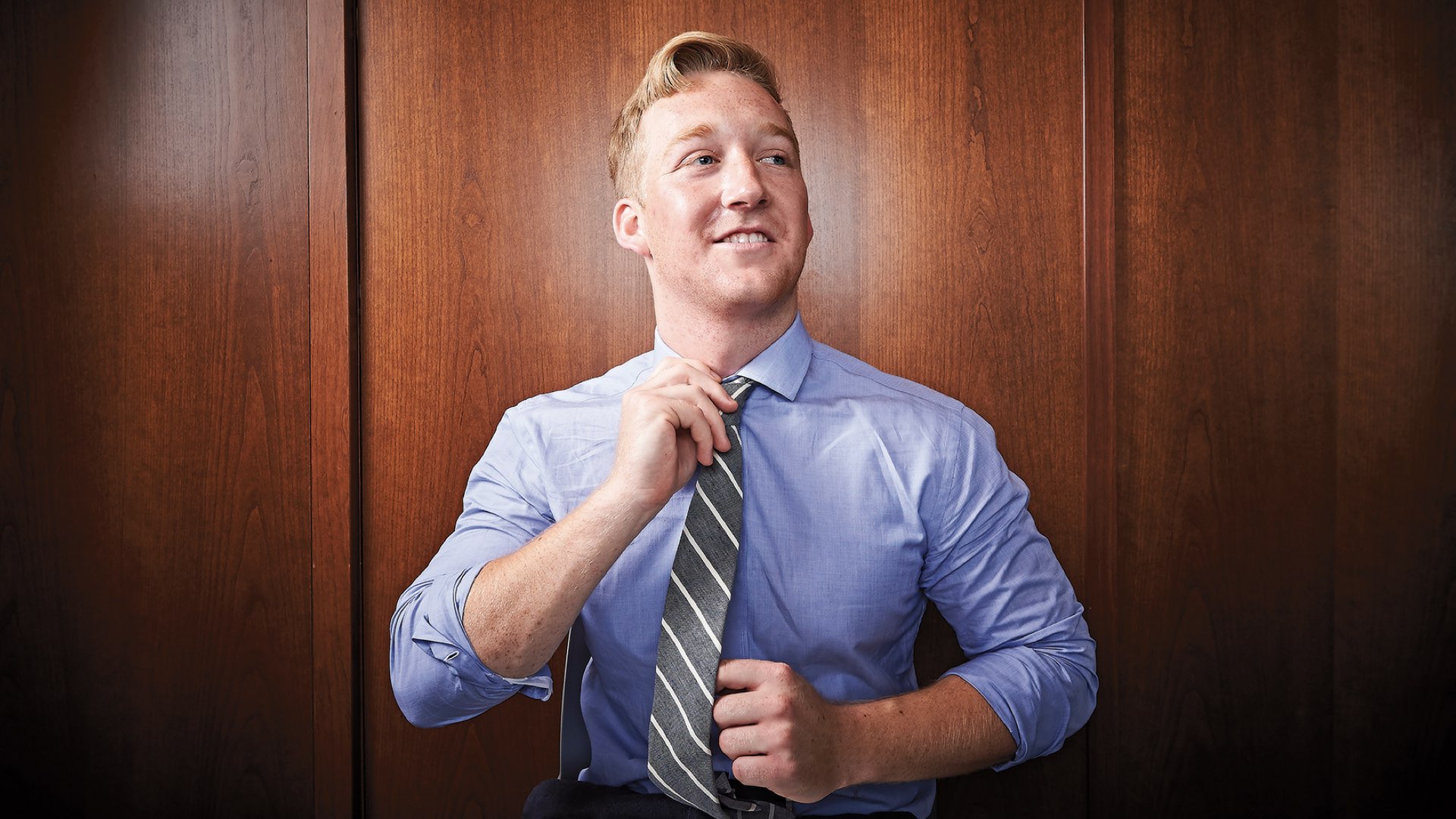 Villanova alumnus Brady Acton straightening a striped tie.