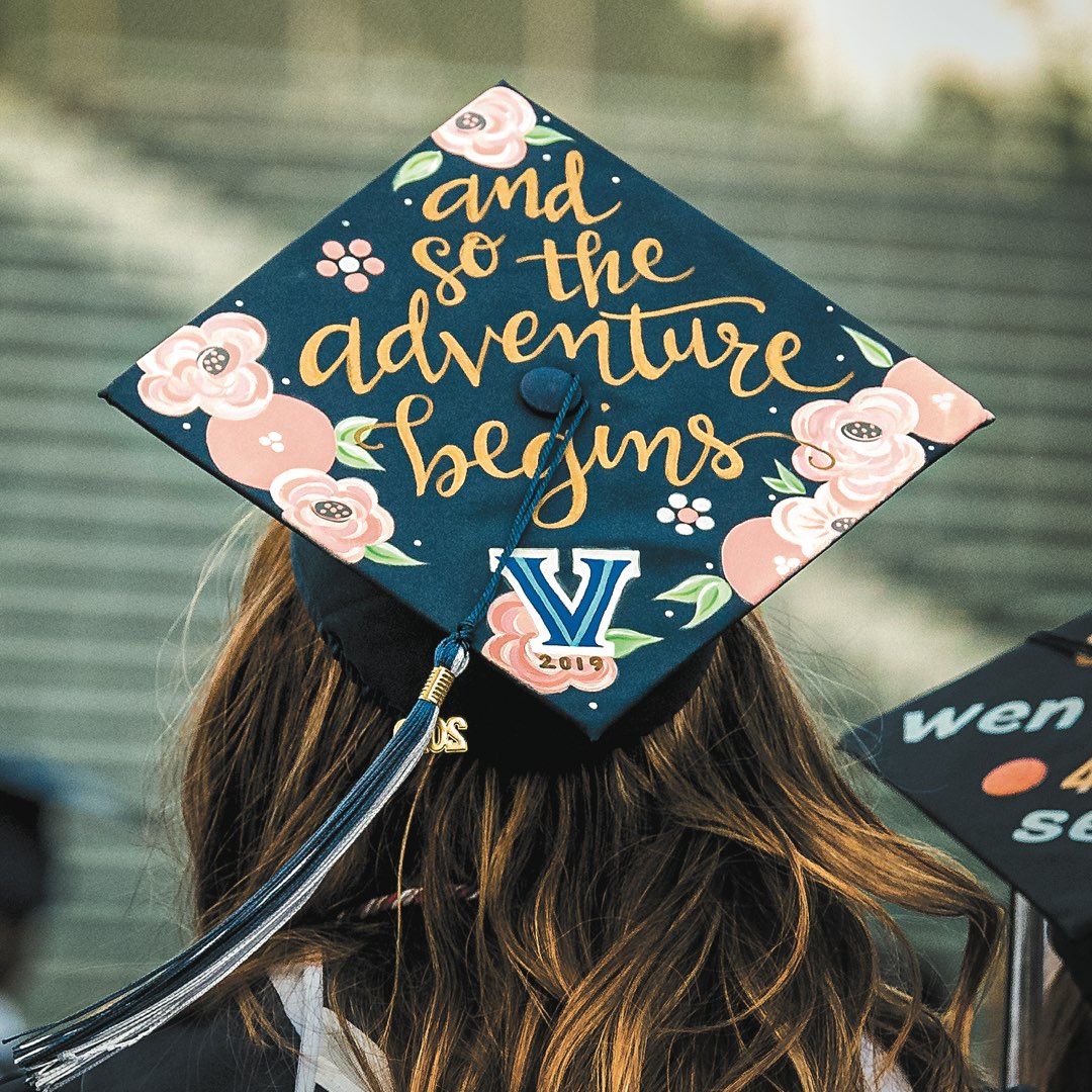 Cap with painted pink flowers and gold lettering that reads “And so the adventure begins”
