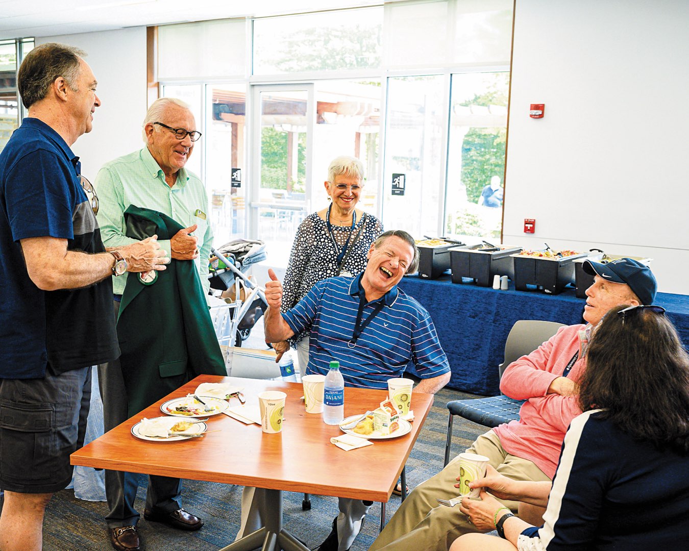 Alums laughing and catching up over a meal