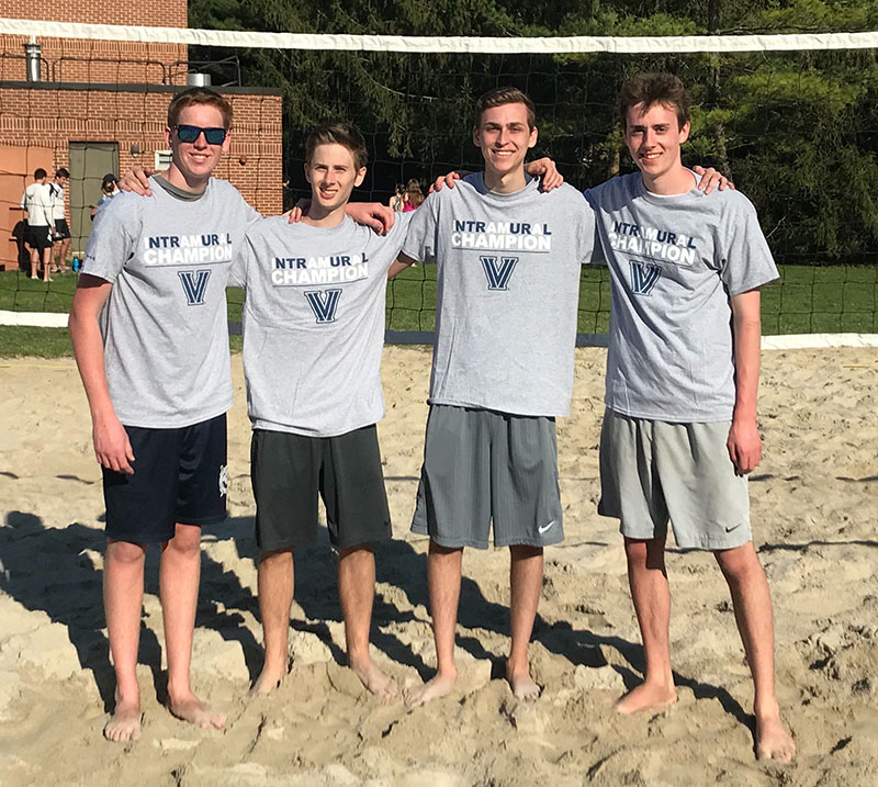 Male students posing for sand volleyball champion photo