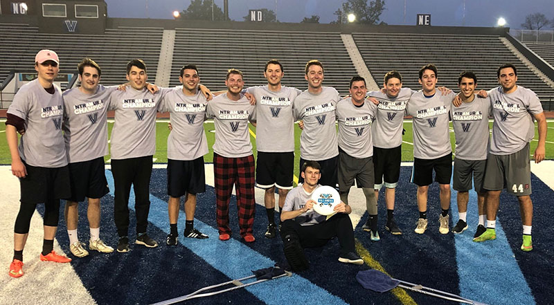 Male students posing for ultimate frisbee champion photo