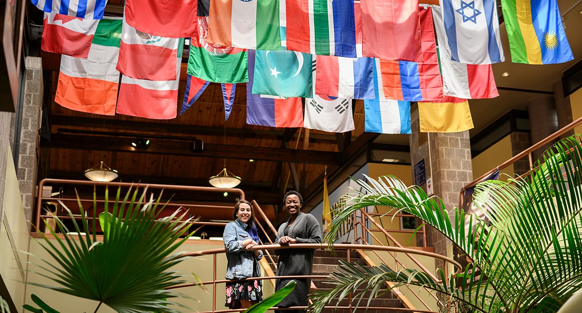 Students standing underneath the flags of the home countries of international students in the student center Students standing underneath the flags of the home countries of international students in the student center