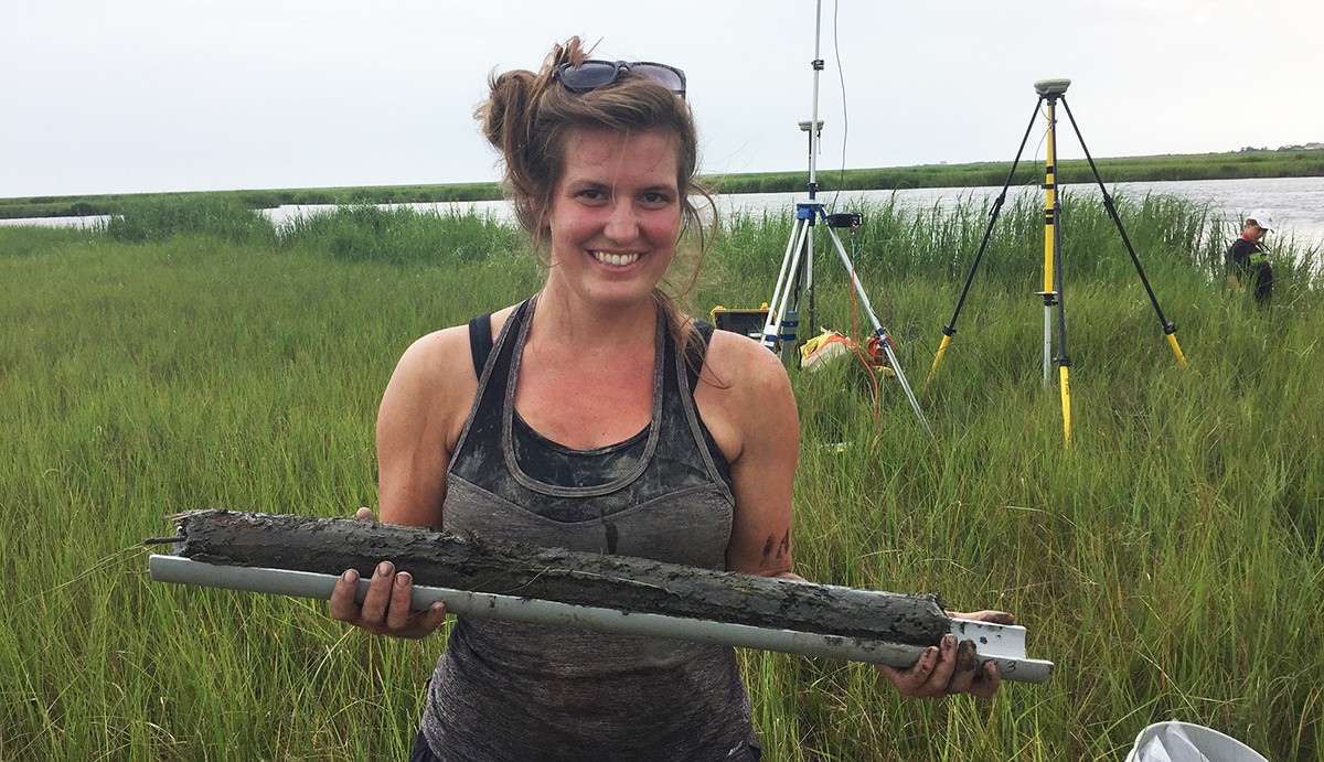 Environmental Science graduate student holding a soil core from a tidal wetlands area. Environmental Science graduate student holding a soil core from a tidal wetlands area.