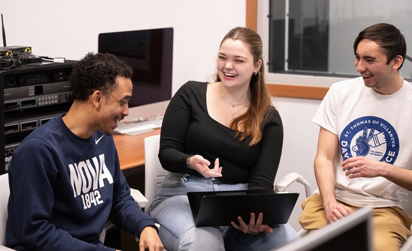 Three students sitting and collaborating on History project.