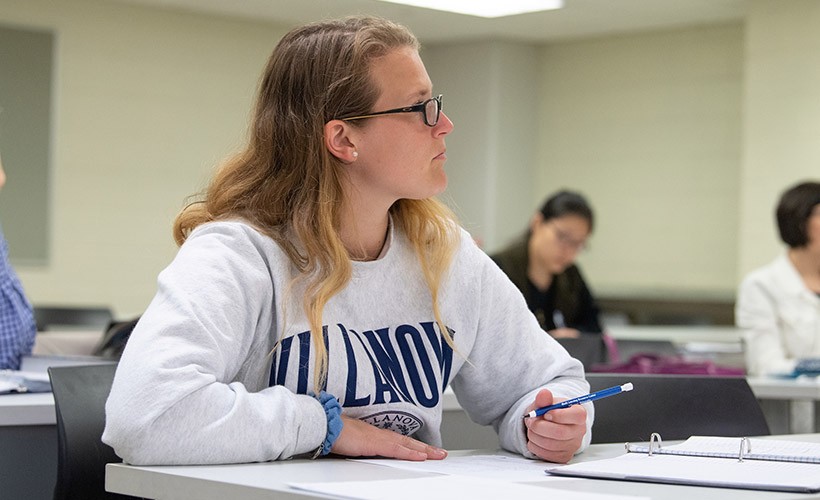 A female student listens to a lecture in a mathematics class.