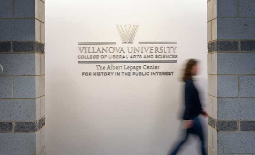 A person walks by the Lepage Center sign outside the office. A person walks by the Lepage Center sign outside the office.