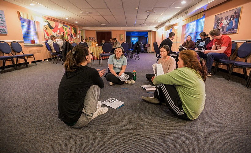 Students sit around in a circle as part of a service experience. Students sit around in a circle as part of a service experience.