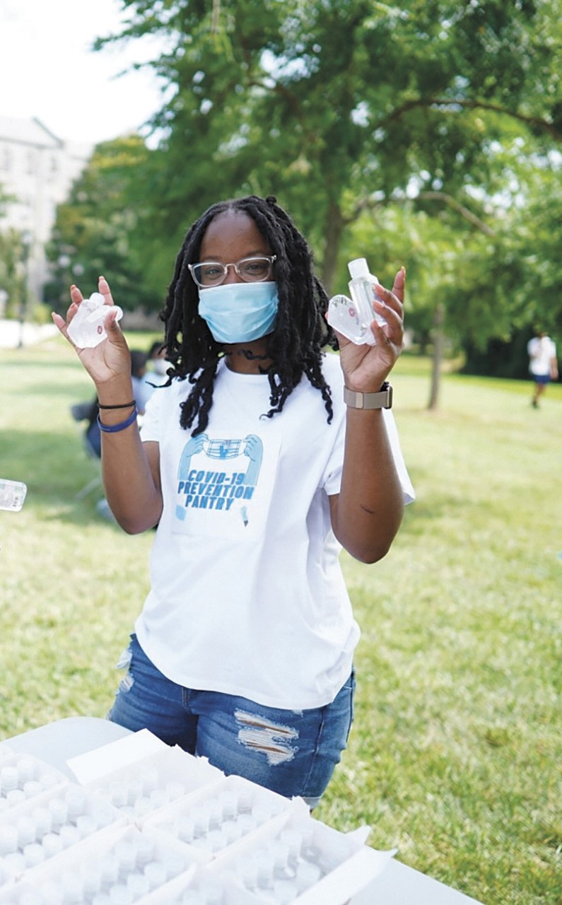 Jasmine Mays Jasmine Mays outside wearing a mask and holding COVID prevention kits