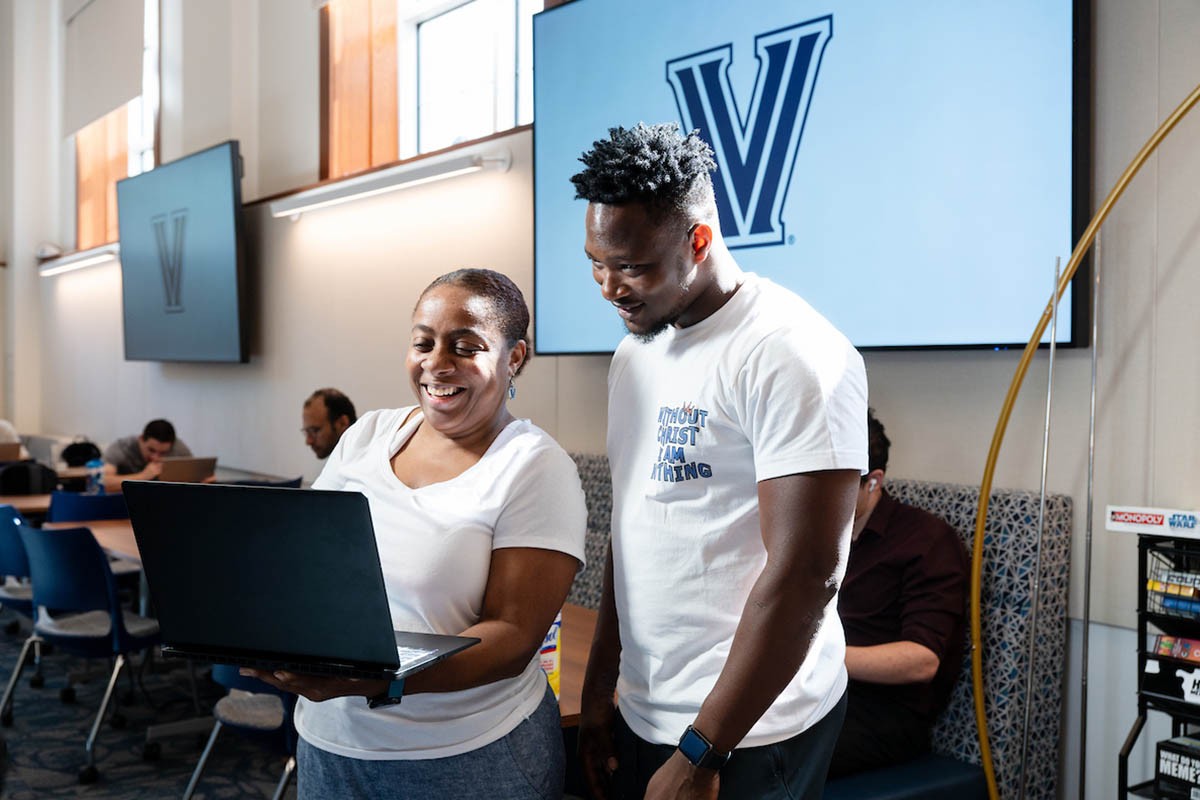 A student and a faculty member looking at something on a laptop