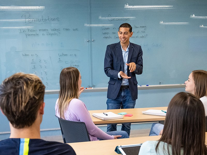 Alexander Diaz-Lopez, PhD, teaches about permutations at the front of a classroom. Alexander Diaz-Lopez, PhD, teaches about permutations at the front of a classroom.