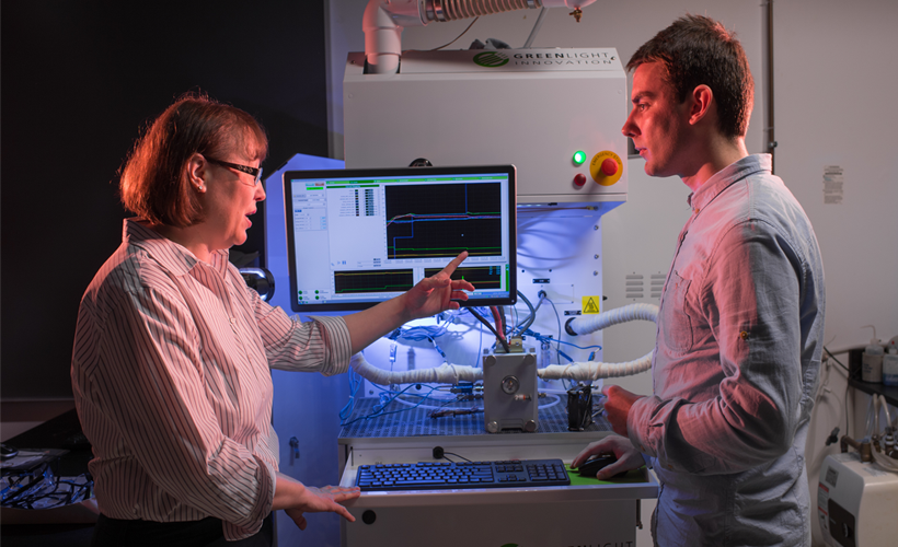 Professor and student viewing monitor in lab