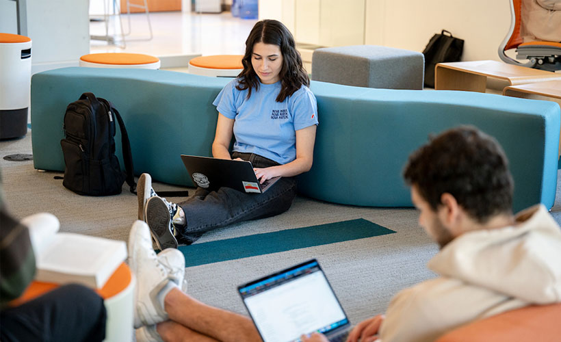 Students sitting on floor using laptops