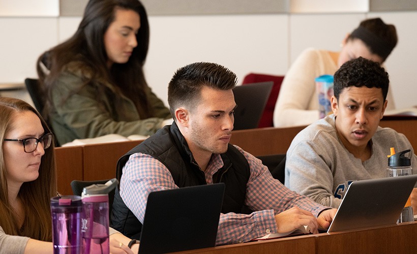 Students work at their computers in a classroom.