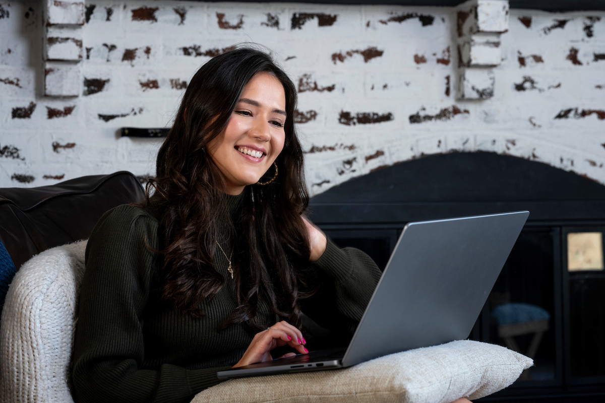 woman sitting on a sofa looking at a laptop